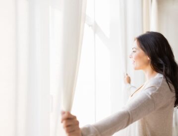 カーテンを開ける女性